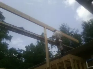 Carpenter setting a ridge beam over a new addition frame — Ice Dam Removal by Roofing Brothers in Doniphan
