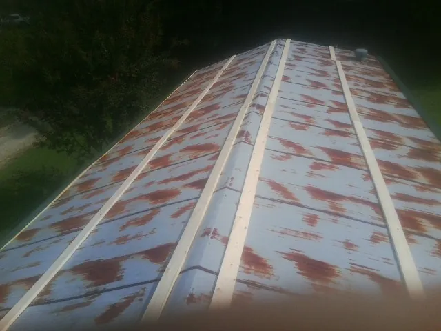 Rusted metal roof panels with new wood purlins before replacement — Storm Damage Roof Repair in Doniphan by Roofing Brothers