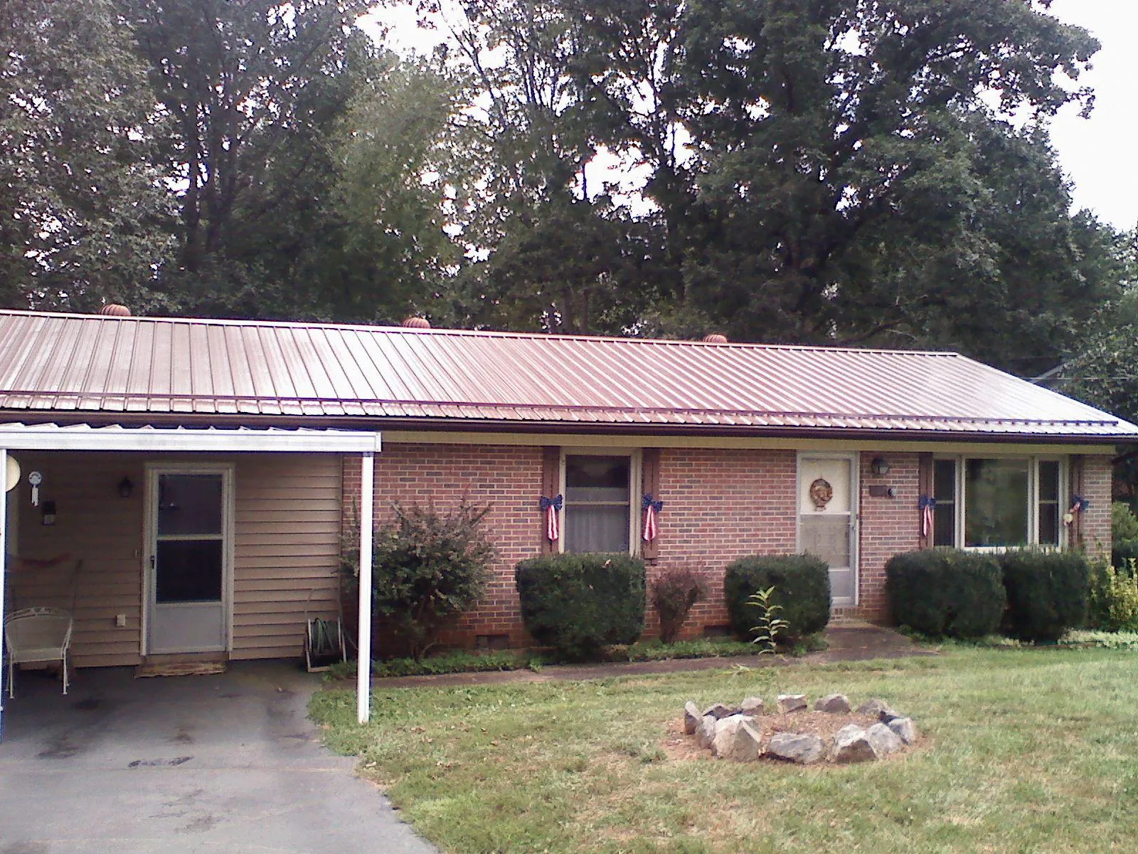 Bronze metal roof and carport on a brick ranch home — Roof Repair work by our crew in Doniphan